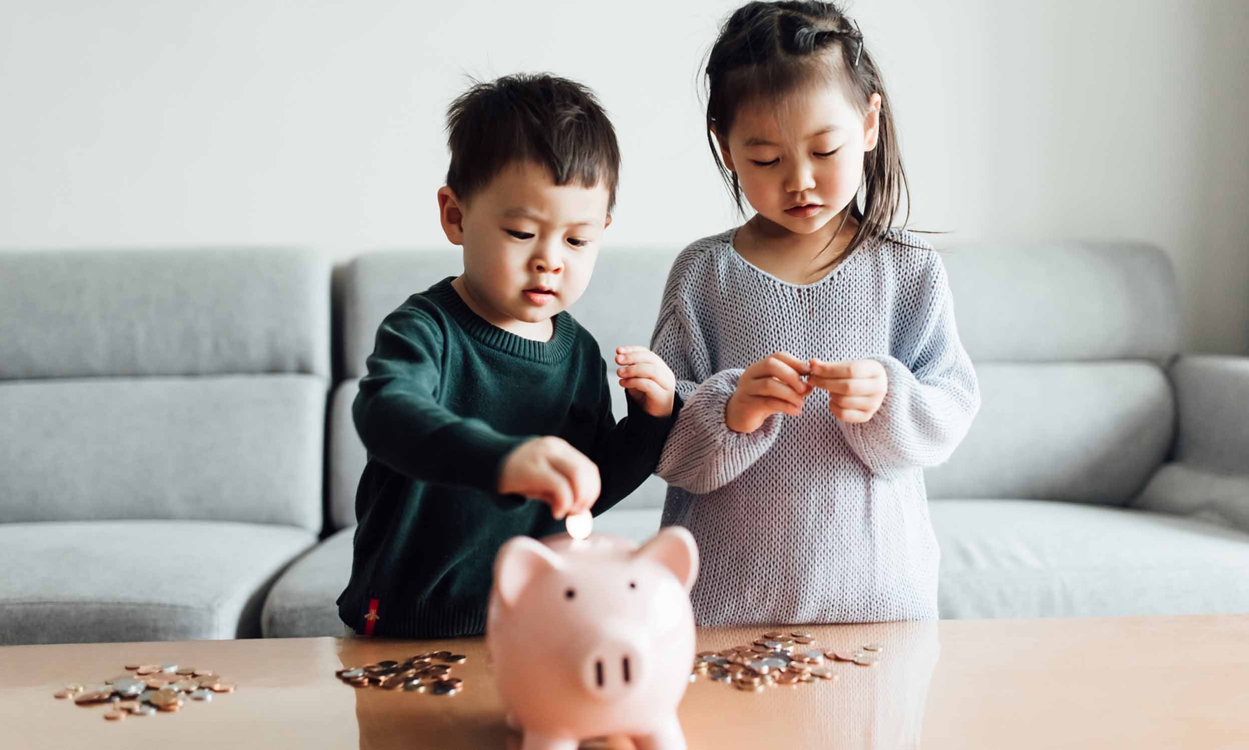 Children playing with the coins and the piggy bank